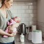Calentador de biberones Momcozy White/Sage en una cocina