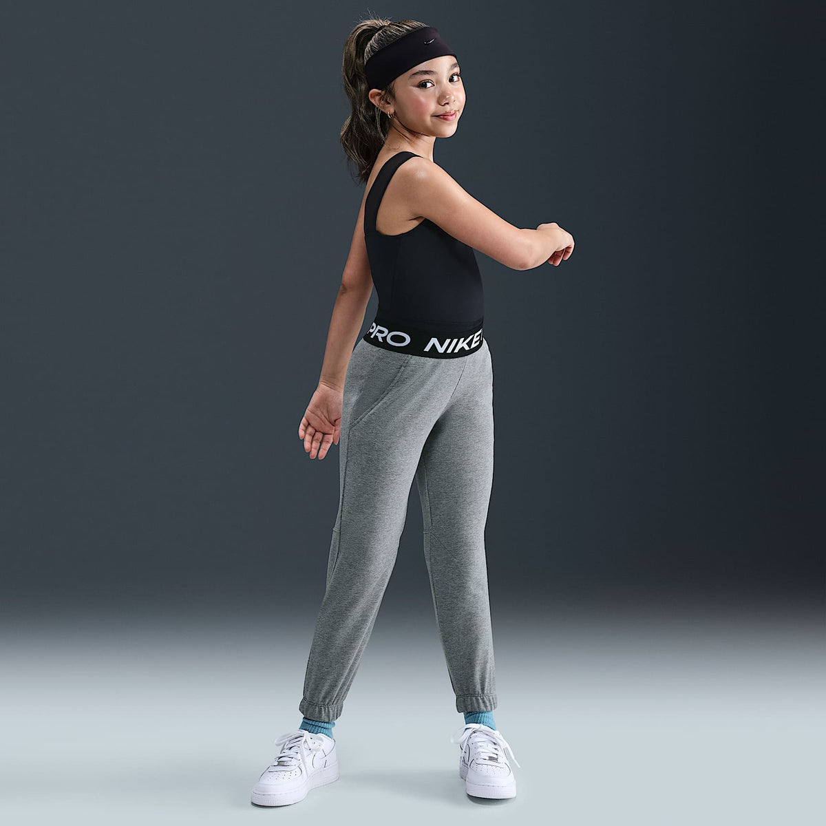 Joggers Dri-FIT para niña talla grande Nike Pro Fleece – Carbono jaspeado/Gris acero oscuro/Negro/Blanco – vista 1